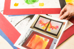 Christine Kroschewski zeigt Fotos von Bildern, die Patienten gemalt haben.