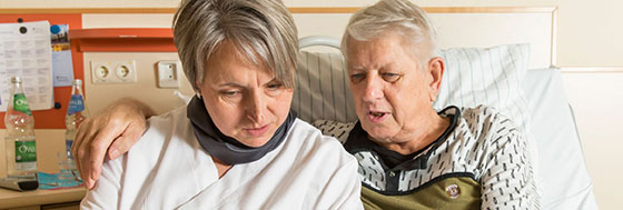 Porträtfoto: Patient und Pflegerin im Gespräch.