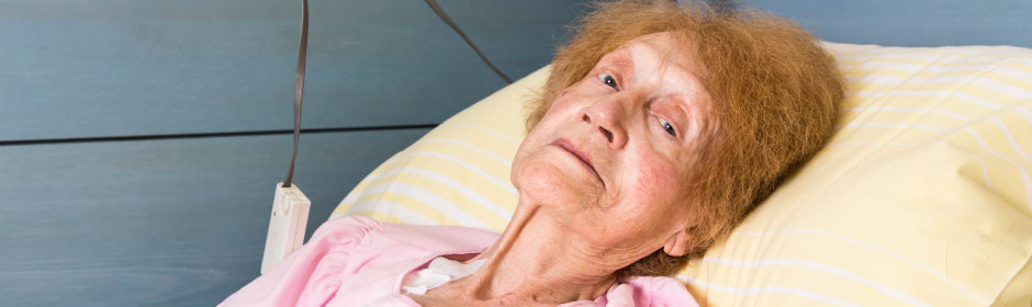 Porträtfoto: alte Dame im Krankenbett.