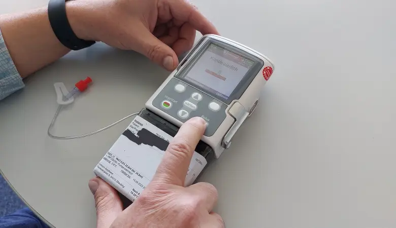 Nahaufnahme der Schmerzpumpe. Das Display zeigt einen roten Balken und den Hinweis: „kontinuierlich“.